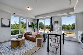 a living room with a couch and a table in front of a window